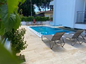 a swimming pool with two chairs and a table next to it at Ressa Apart in Marmaris