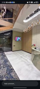 a living room with a tv and a room with a floor at AMARANT hotel in Baysun