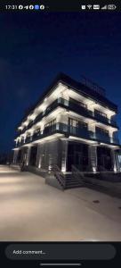 a large white building with a sign on top of it at AMARANT hotel in Baysun