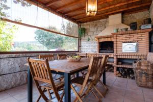 a wooden table and chairs on a patio with an oven at Feel Discovery Maçã Douro in Armamar