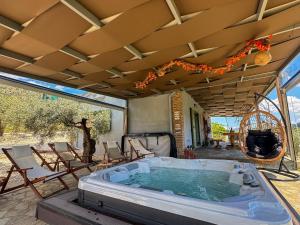 a hot tub on the patio of a house at Elaia Rest House Retreat in nature in Fréngaina