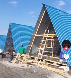 two men working on a house under construction at Cuyabeno Glamping in Cuyavenus