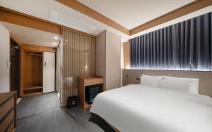 a bedroom with a large white bed and a fireplace at Gwangju The IN Hotel in Gwangju +46 photos