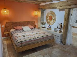 a bedroom with a bed with an orange wall at La Cale de la Clauderie in Rigny-Ussé +54 photos