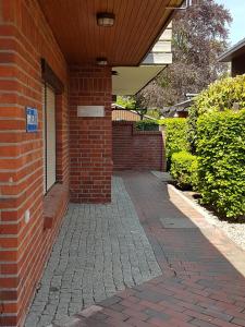 a brick building with a brick walkway in front of it at Wattliebe Burhave in Burhave +3 photos