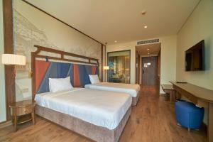 a hotel room with two beds and a desk at Apec Mandala Ocean Retreat- Mui Ne in Mui Ne +58 photos