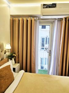 ein Schlafzimmer mit einem Bett und einem Fenster mit Vorhängen in der Unterkunft Angel's Haven in Manila