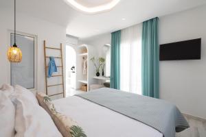 a white bedroom with a large bed and a window at Iades Studios & Apartments in Agia Anna Naxos