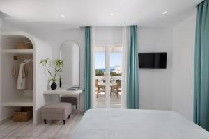 a bedroom with a bed and a table with a chair at Iades Studios & Apartments in Agia Anna Naxos