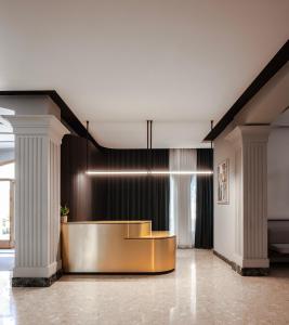 eine Lobby mit einem goldenen Schreibtisch und Säulen in der Unterkunft Il Palazzin Hotel in St Paul's Bay + 72 Fotos