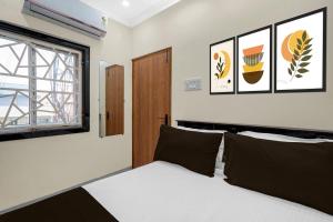 a bedroom with a bed and a window at Hotel O The Royal Guest Rooms in Vijayawāda