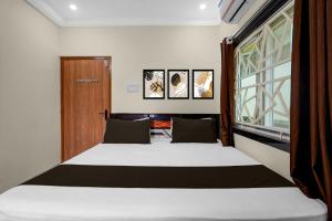 a bedroom with a bed and a window at Hotel O The Royal Guest Rooms in Vijayawāda +25 photos