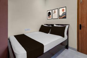 a bedroom with a bed with black and white sheets at Hotel O The Royal Guest Rooms in Vijayawāda