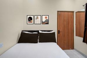 a bedroom with a bed with four pictures on the wall at Hotel O The Royal Guest Rooms in Vijayawāda