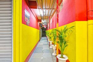 a hallway with colorful walls and potted plants at Super Hotel O Rishra Railway Station Formerly Green Guest House in Khardah