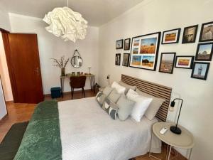 a bedroom with a large white bed with a chandelier at Casa D' Oliveira in Castro Verde +32 photos