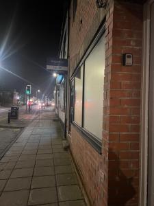 an empty sidewalk next to a brick building at night at Fully Equipped Homely Heaven in Houghton le Spring