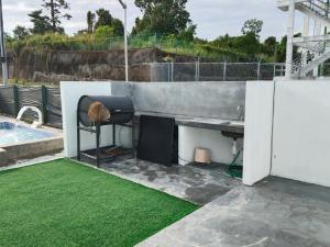a patio with green grass next to a pool at Teratak Saharah Homestay in Port Dickson