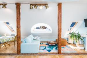 a living room with wooden beams and a blue couch at Rüütli Residents in Pärnu