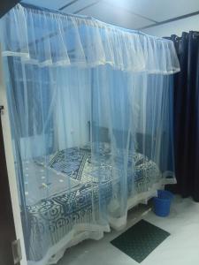 a bedroom with a bed under a curtain at Trailside Homestay in Badulla