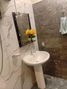 a bathroom with a sink and a mirror at Trailside Homestay in Badulla