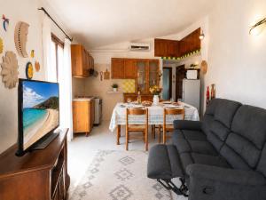 a kitchen and a living room with a table and a tv at Piazzetta Dei Pini Two Bedroom Apartment 100 m from the Beach in Baja Sardinia