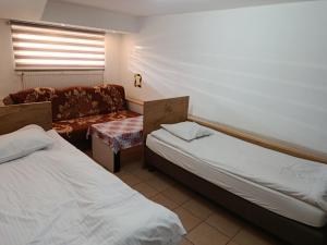 a hotel room with two beds and a couch at Fenix Grzybno pokoje pracownicze, rodzinne, typu standard,dłuższe pobyty in Grzybno
