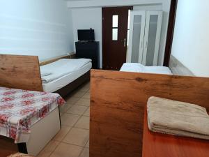 a room with two beds and a table in it at Fenix Grzybno pokoje pracownicze, rodzinne, typu standard,dłuższe pobyty in Grzybno