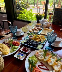 a wooden table with plates of food on it at La Fontaine de Tara Boutique Hotel in Siem Reap