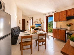 a kitchen and living room with a table and a refrigerator at Piazzetta Dei Pini Two Bedroom Apartment 100 m from the Beach in Baja Sardinia