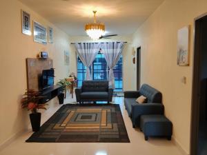 a living room with a couch and chairs and a tv at Teratak Saharah Homestay in Port Dickson