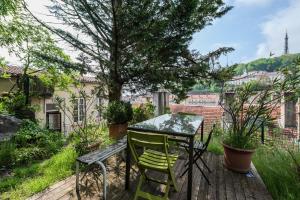 a table and chairs on a wooden deck with a tree at Les Jardins Suspendus in Lyon