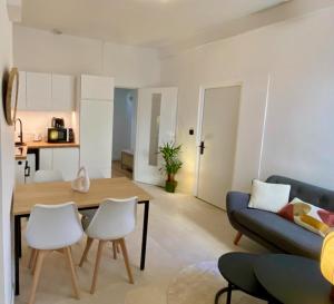 a living room with a couch and a table and chairs at Les Jardins Suspendus in Lyon