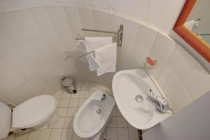 a white bathroom with a toilet and a sink at La Gaubertière in Saint-Paul-du-Bois +5 photos