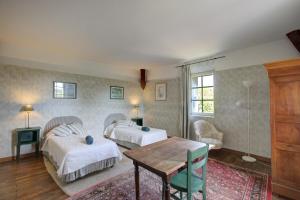 a hotel room with two beds and a table at La Gaubertière in Saint-Paul-du-Bois