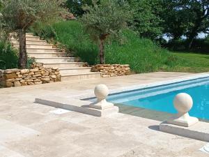 a swimming pool with concrete barriers next to a stairway at Les Volets Verts-Dordogne in Plazac +15 photos