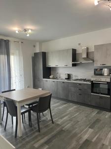a kitchen with a wooden table and a table and chairs at Paky' S House in Policoro
