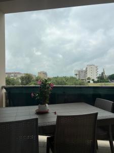 a table with a vase of flowers on a balcony at Paky' S House in Policoro
