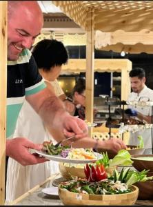 a man preparing a plate of food in a kitchen at Wadi Rum Nader Luxury Camp in Wadi Rum