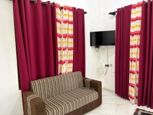 a living room with red curtains and a chair at Yala Dream Guest House in Tissamaharama