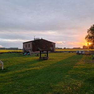 an old barn in the middle of a field at sunset at Casabandow in Schwaan