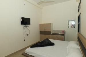a bedroom with a bed and a flat screen tv at Hotel Deeksha in Mandlā