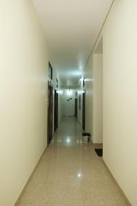 an empty hallway with white walls and a long corridor at Hotel Deeksha in Mandlā