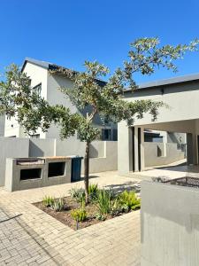 a house with a tree in front of it at Elusive Haven in Nelspruit