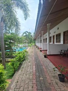 a walkway outside a building next to a pool at Nilaveli Shan Guest in Trincomalee