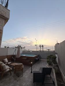 a patio with a couch and chairs and a pool at SeaSide Villa in Ashdod
