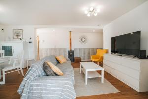 a living room with a couch and a flat screen tv at Casa de Salgueiros in Canidelo