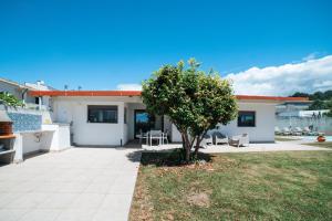 a house with a patio and a tree in the yard at Casa de Salgueiros in Canidelo