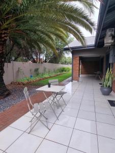 a patio with a table and two chairs on it at Grey Corner Guesthouse in Postmasburg