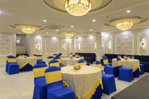 a banquet hall with blue and yellow tables and chairs at Ginger Kota, Vishwakarma Nagar in Kota